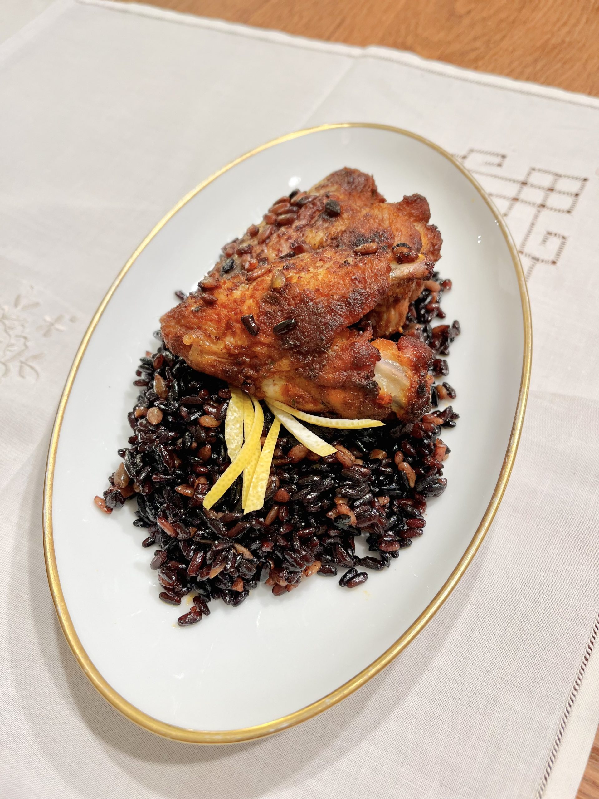 Hähnchenflügel auf schwarzem Reis
